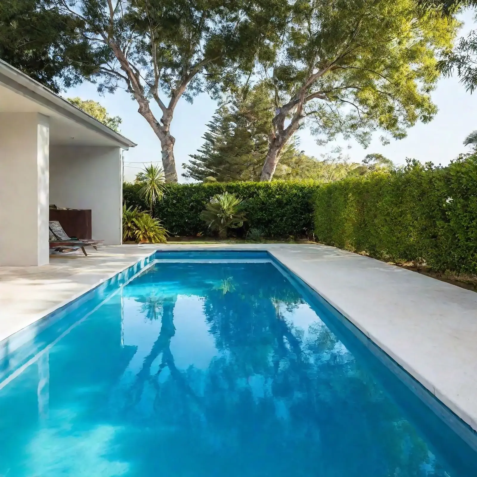 Non-slip concrete pool surround beside a backyard pool