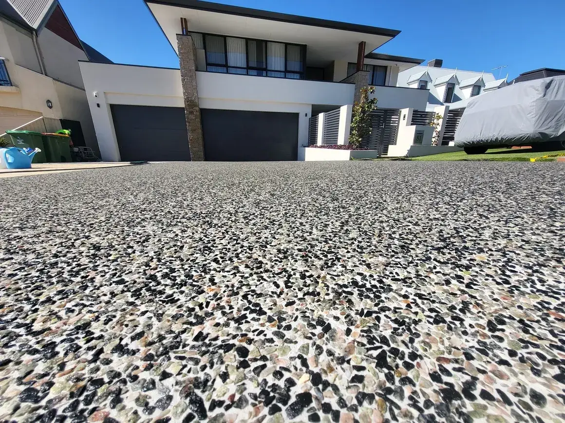 Exposed aggregate concrete driveway with decorative stone finish
